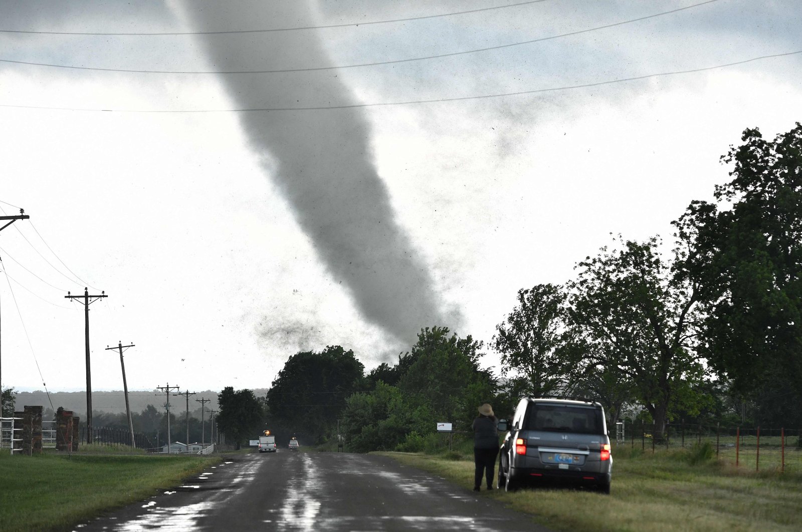 A woman looks on while a tornado rips through a residential area after touching down south of Wynnewood, Oklahoma, U.S., May 8, 2016. (Josh Edelson via AFP)