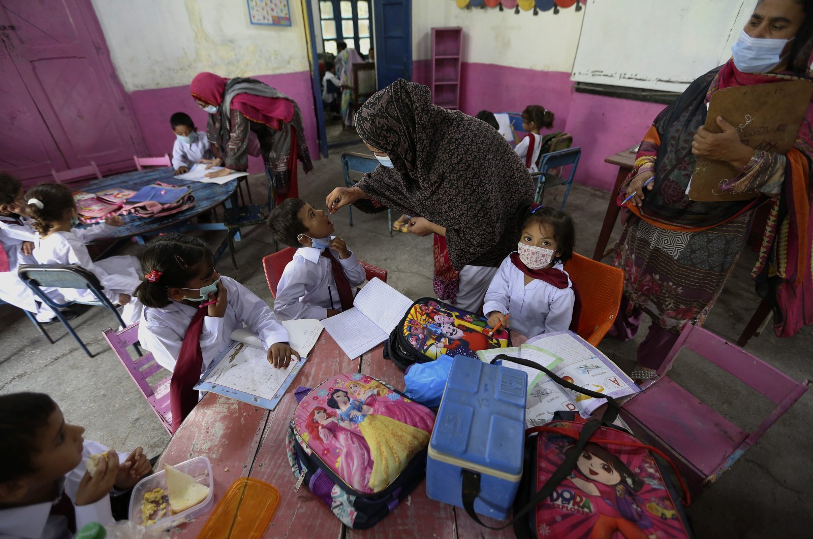 A health worker administers a polio vaccine to a child at a school in Lahore, Pakistan, Monday, Aug. 2, 2021. (AP File Photo)