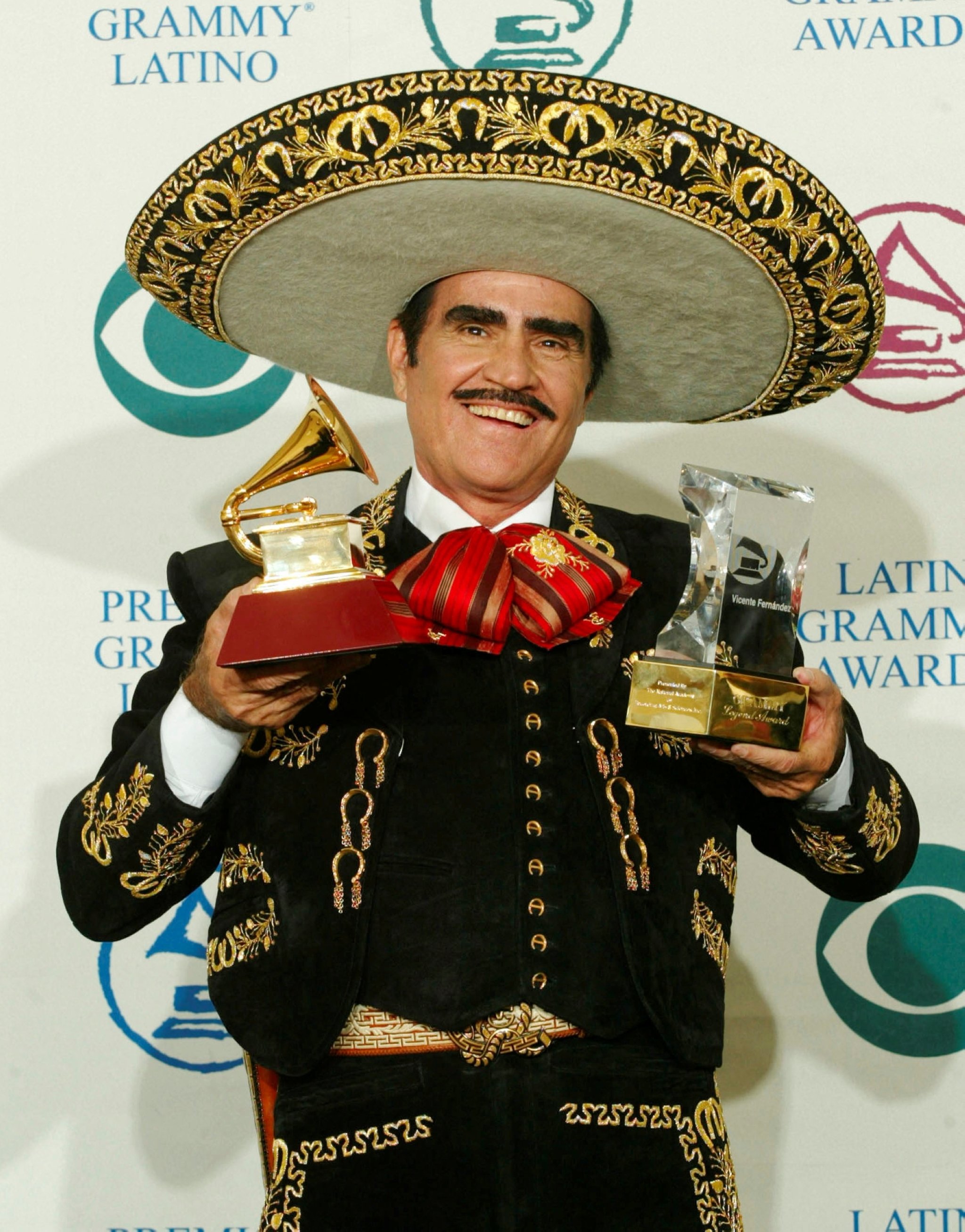 Mexican singer Vicente Fernandez holds up the Latin Grammy award (L) for best ranchero album he won for 
