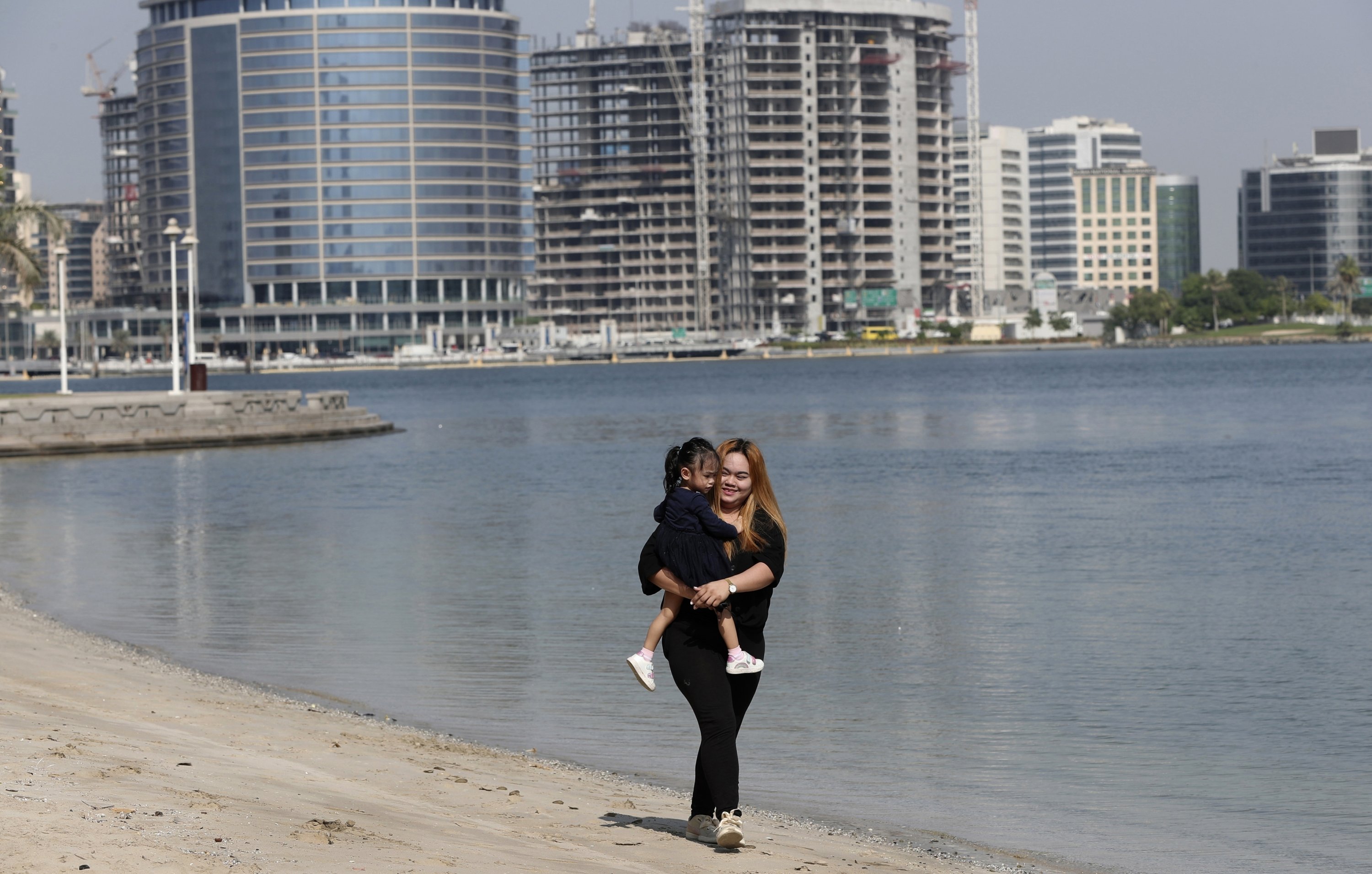 Sitte Honey, 25, carries her 2-year-old undocumented daughter Naya at a park in Dubai, United Arab Emirates, Nov. 23, 2021. (AP Photo)