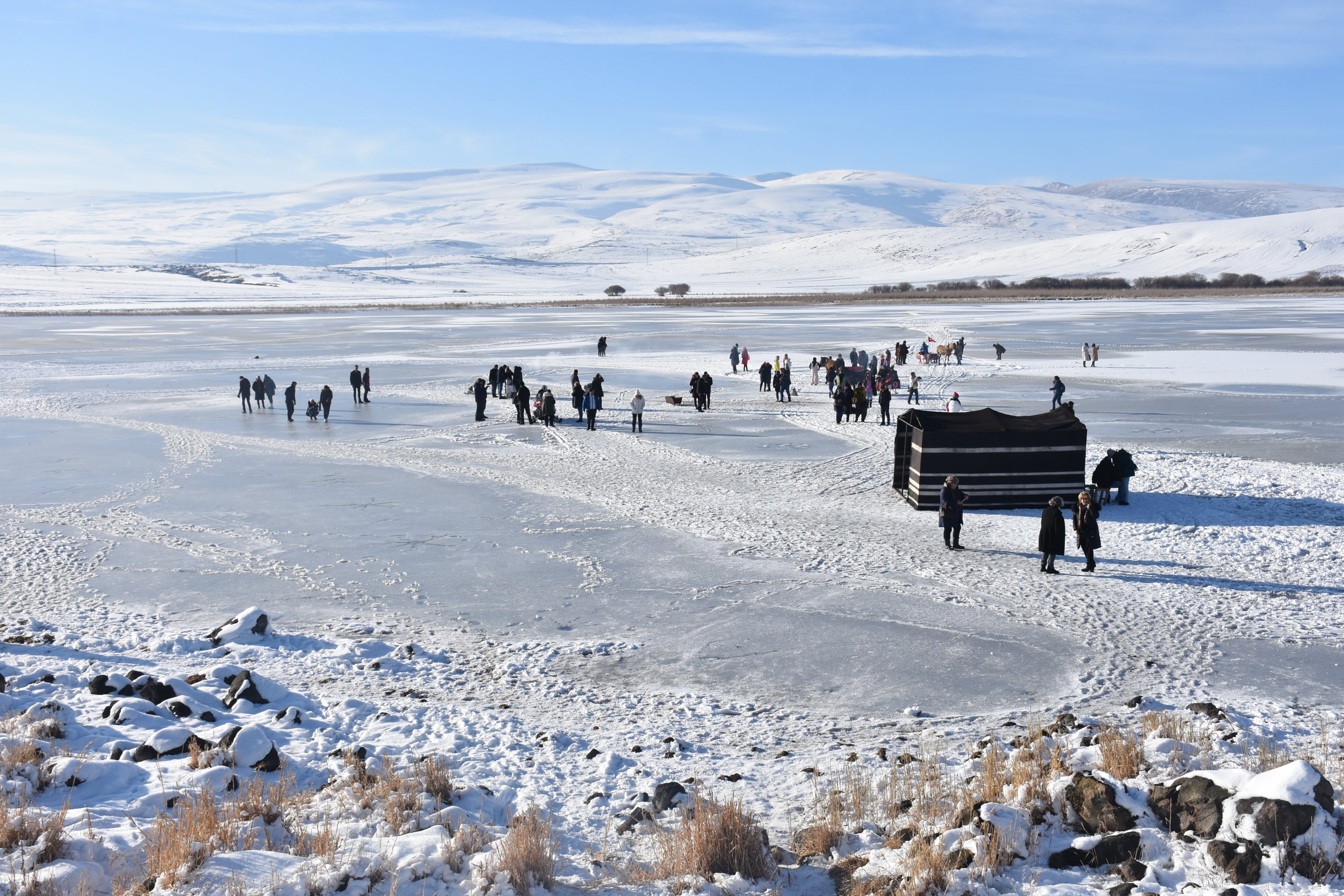 People walking on the frozen surface of Lake Çıldır in the Çıldır district of Ardahan province, eastern Turkey, Dec. 12, 2021. (AA Photo)