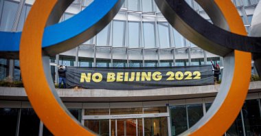 Tibetan activists hold a placard during a protest at the entrance of the IOC headquarters in Lausanne, Switzerland, Dec. 11, 2021. (AFP Photo)