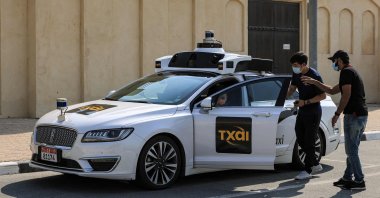 Passengers enter one of the self-driving taxis being used in a tech demonstration to transport passengers to the nearby Yas Island, in the capital Abu Dhabi, United Arab Emirates, Nov. 30, 2021. (AFP Photo)