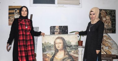 Zemzem Gök (R) and Fatma Dendüş pose with a mosaic they created together in their workshop, Hatay, southern Turkey, Dec. 12, 2021. (AA)