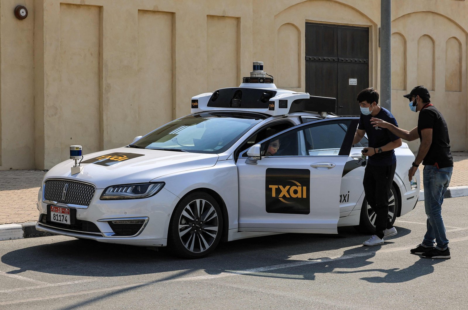 Passengers enter one of the self-driving taxis being used in a tech demonstration to transport passengers to the nearby Yas Island, in the capital Abu Dhabi, United Arab Emirates, Nov. 30, 2021. (AFP Photo)