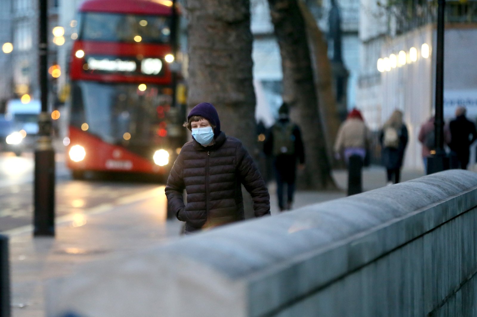 A man wearing a mask walks on a busy London street, U.K., Dec. 12, 2021. (AA Photo)