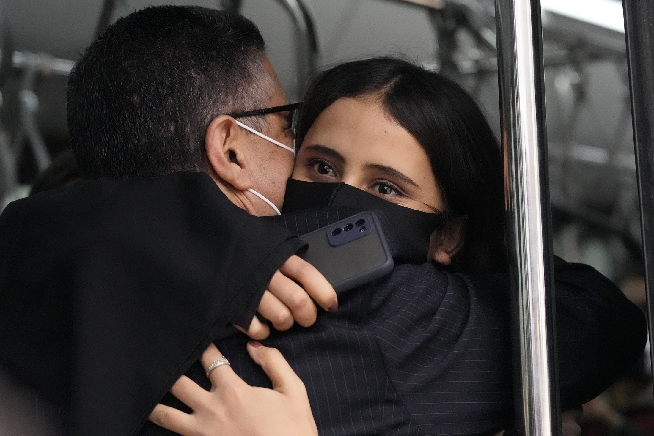 Afghan musician Marzia Anwari (R), hugs Ahmad Naser Sarmast, founder and director of the Afghanistan National Institute of Music, inside a bus after she disembarked from an airplane at a military airport, in Lisbon, Portugal, Dec. 13, 2021. (AP Photo)