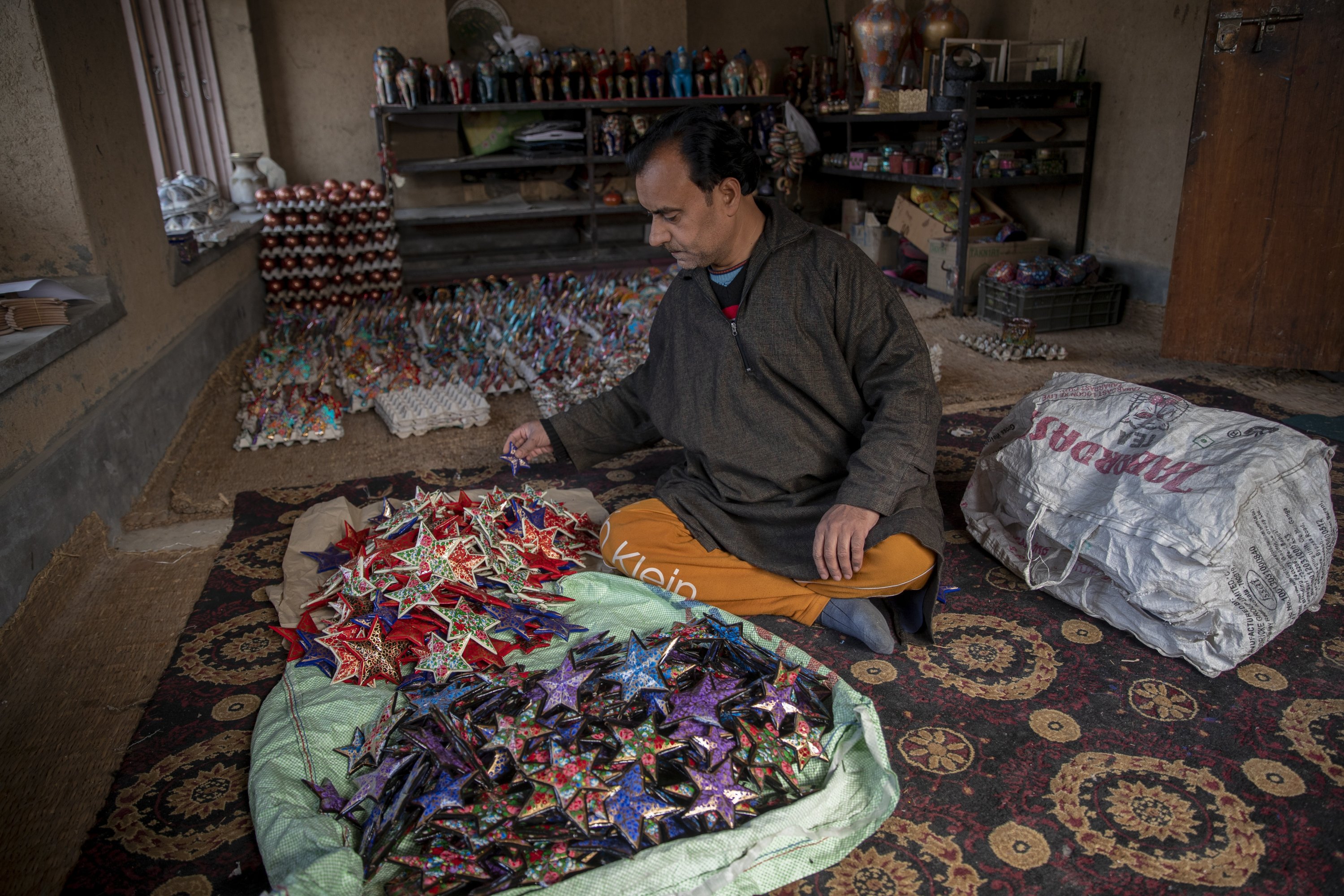 A Kashmiri artist arranges Christmas-related items made of papier-mache at a workshop in Srinagar, Kashmir, Wednesday, Nov. 3, 2021. (AP)
