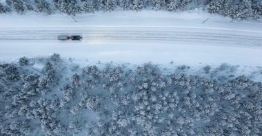 An aerial shot shows a car as it drives on a road through the Arctic wilderness close to Utsjoki, Finland, Nov. 25, 2021. (AFP Photo)