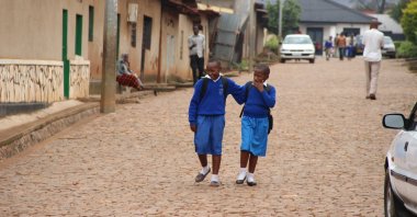 Two young school girls in uniform walk on their way home after class, in Kigali, Rwanda, July, 2016. (Shutterstock Photo)