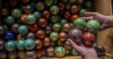 A Kashmiri artist holds Christmas gift items of papier-mache at a workshop in Srinagar, Kashmir, Wednesday, Nov. 3, 2021. (AP)
