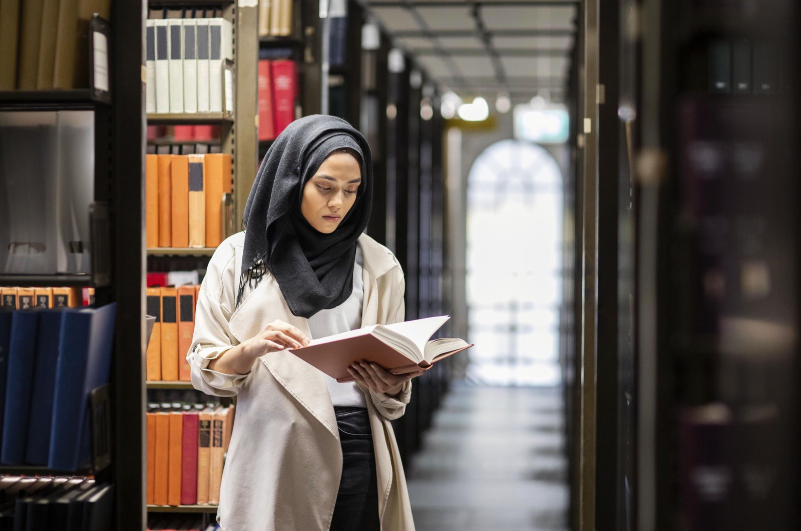 A woman wearing a headscarf reads a book. (Getty Images)