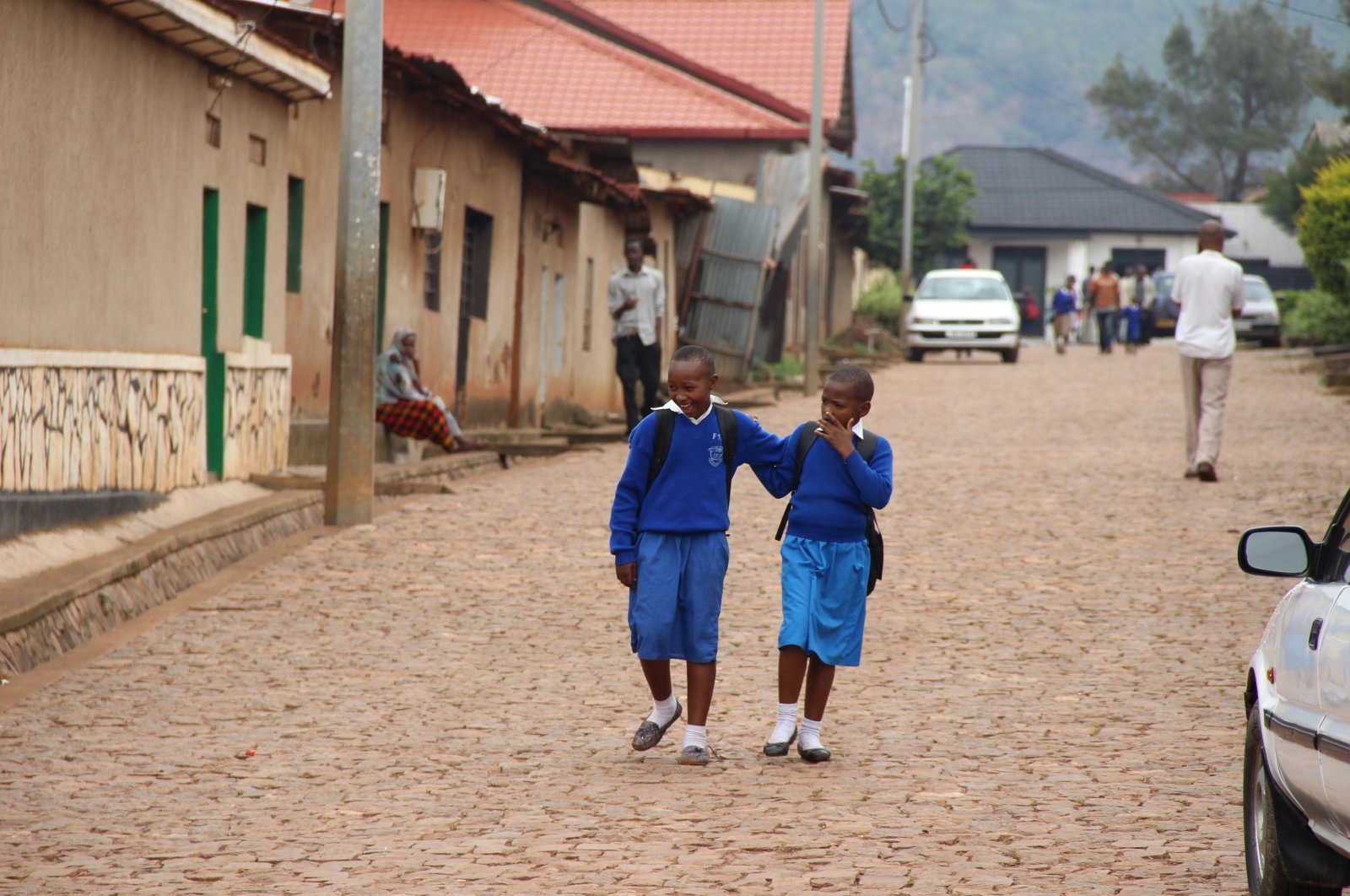 Two young school girls in uniform walk on their way home after class, in Kigali, Rwanda, July, 2016. (Shutterstock Photo)