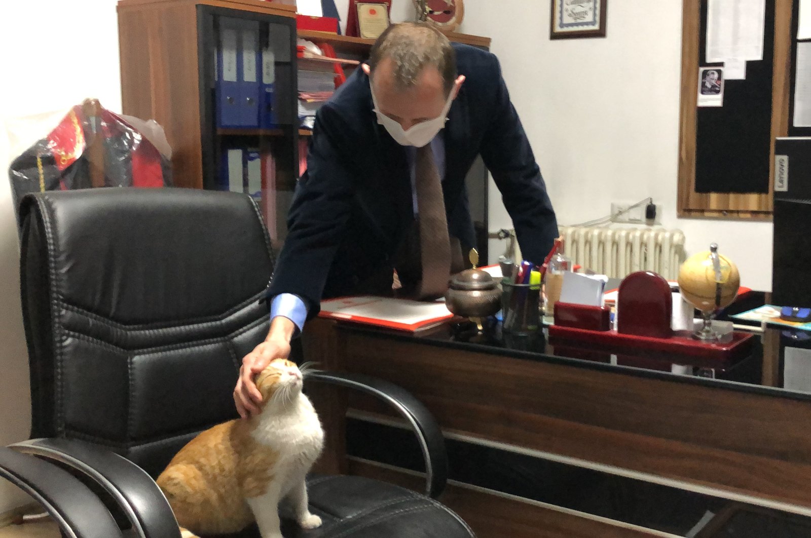 Prosecutor Ozan Oğuz pets Ziya the cat in his room, in Germencik, in Aydın, western Turkey, Dec. 14, 2021. (AA PHOTO) 
