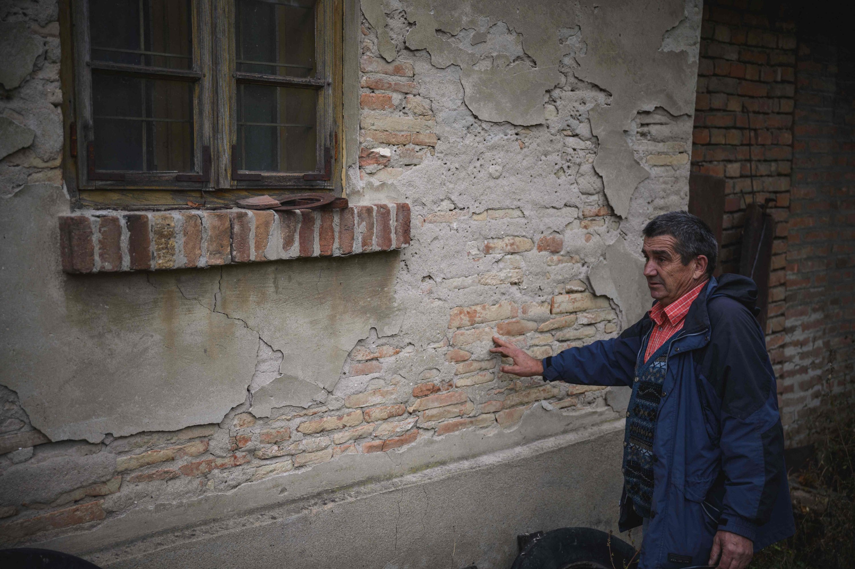 Dragan Jacanovic, an archeologist from the Museum of Pozarevac, shows the ancient Roman bricks in a wall of a house, Stari Kostolac, Serbia, Dec. 3, 2021. (AFP Photo)