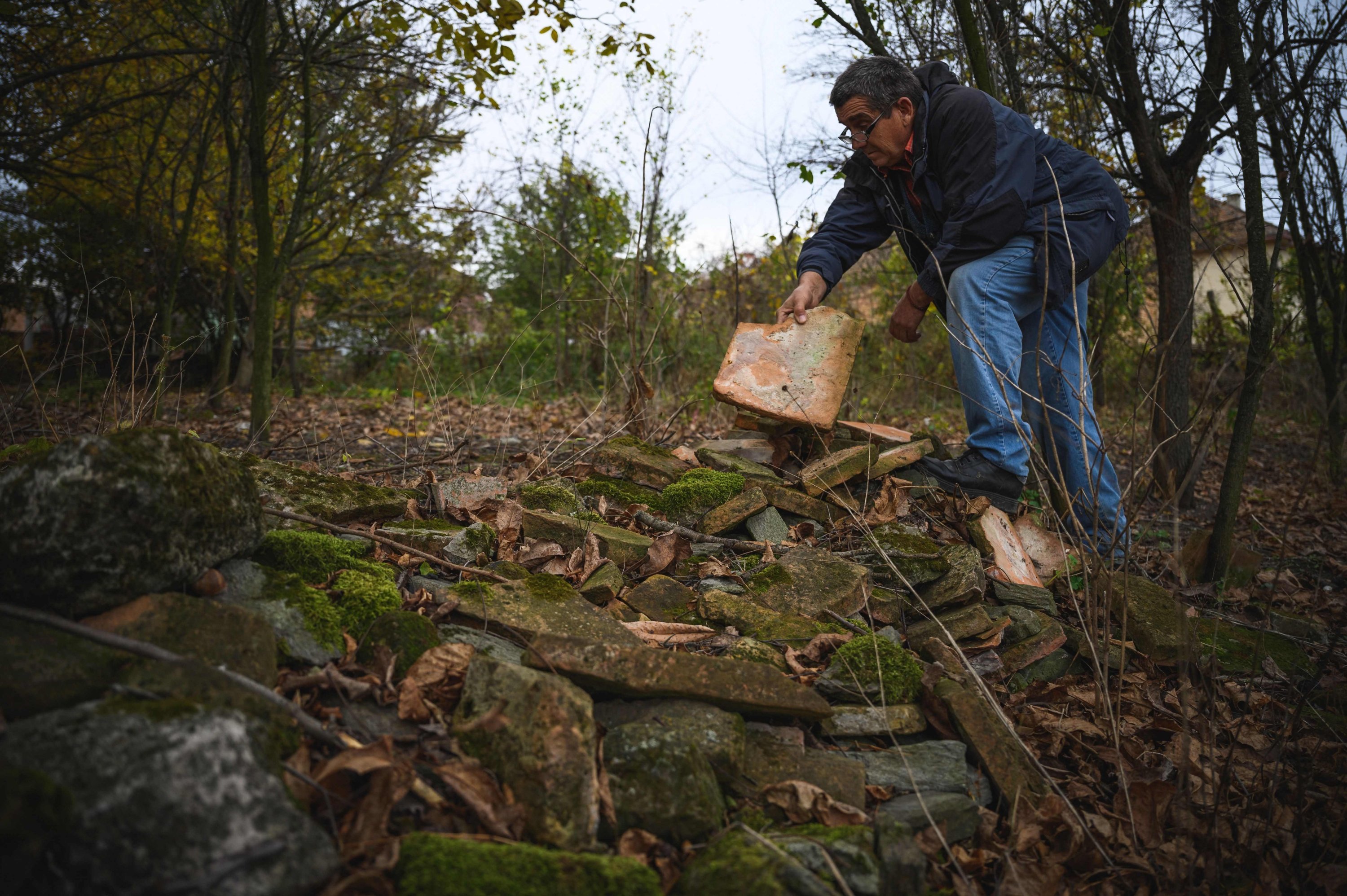 Dragan Jacanovic, an archeologist from the Museum of Pozarevac, shows a brick with Roman stamps on it from a pile, Stari Kostolac, Serbia, Dec. 3, 2021. (AFP Photo)