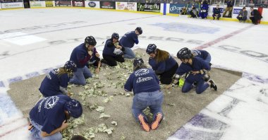Local teachers scramble for dollar bills to fund projects for their classrooms in the first-ever Dash For Cash between periods at the Sioux Falls Stampede game, South Dakota, U.S., Dec. 11, 2021. (AP Photo)