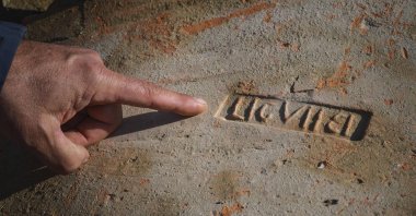 Dragan Jacanovic, an archeologist from the Museum of Pozarevac, points to a brick with Roman stamps on it in Stari Kostolac, Serbia, Dec. 3, 2021. (AFP Photo)
