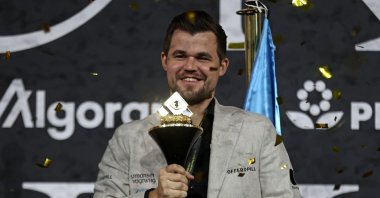 Norwegian grandmaster Magnus Carlsen poses with the FIDE World Chess Championship trophy, Dubai, UAE, Dec. 12, 2021. (AFP Photo)
