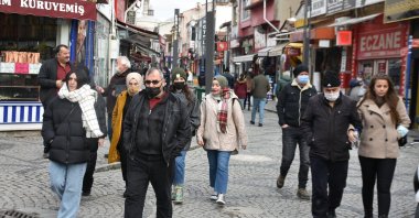 A mix of people wearing and not wearing protective masks against COVID-19 walk on a street in Edirne, northwestern Turkey, Dec. 15, 2021. (DHA PHOTO) 