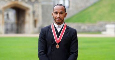 Mercedes' British F1 driver Lewis Hamilton poses with his medal after being appointed as a Knight Bachelor (Knighthood) for services to motorsports, by Britain's Prince Charles, Prince of Wales, during an investiture ceremony at Windsor Castle in Windsor, west of London, Dec. 15, 2021. (AFP Photo)