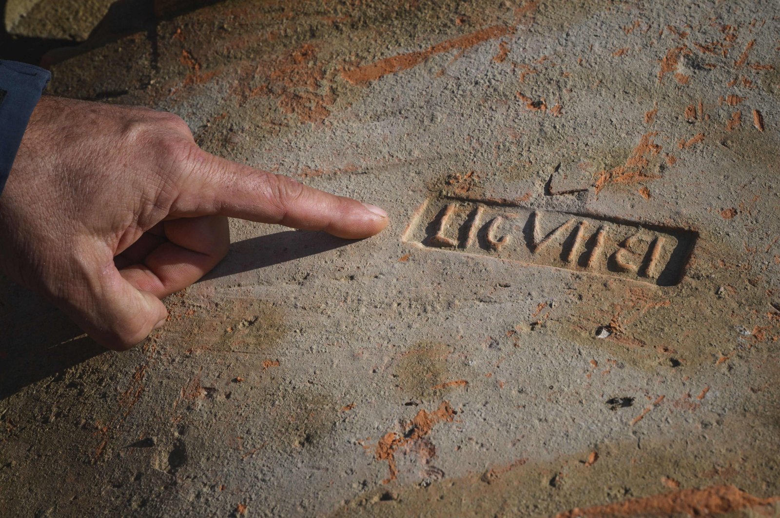 Dragan Jacanovic, an archeologist from the Museum of Pozarevac, points to a brick with Roman stamps on it in Stari Kostolac, Serbia, Dec. 3, 2021. (AFP Photo)