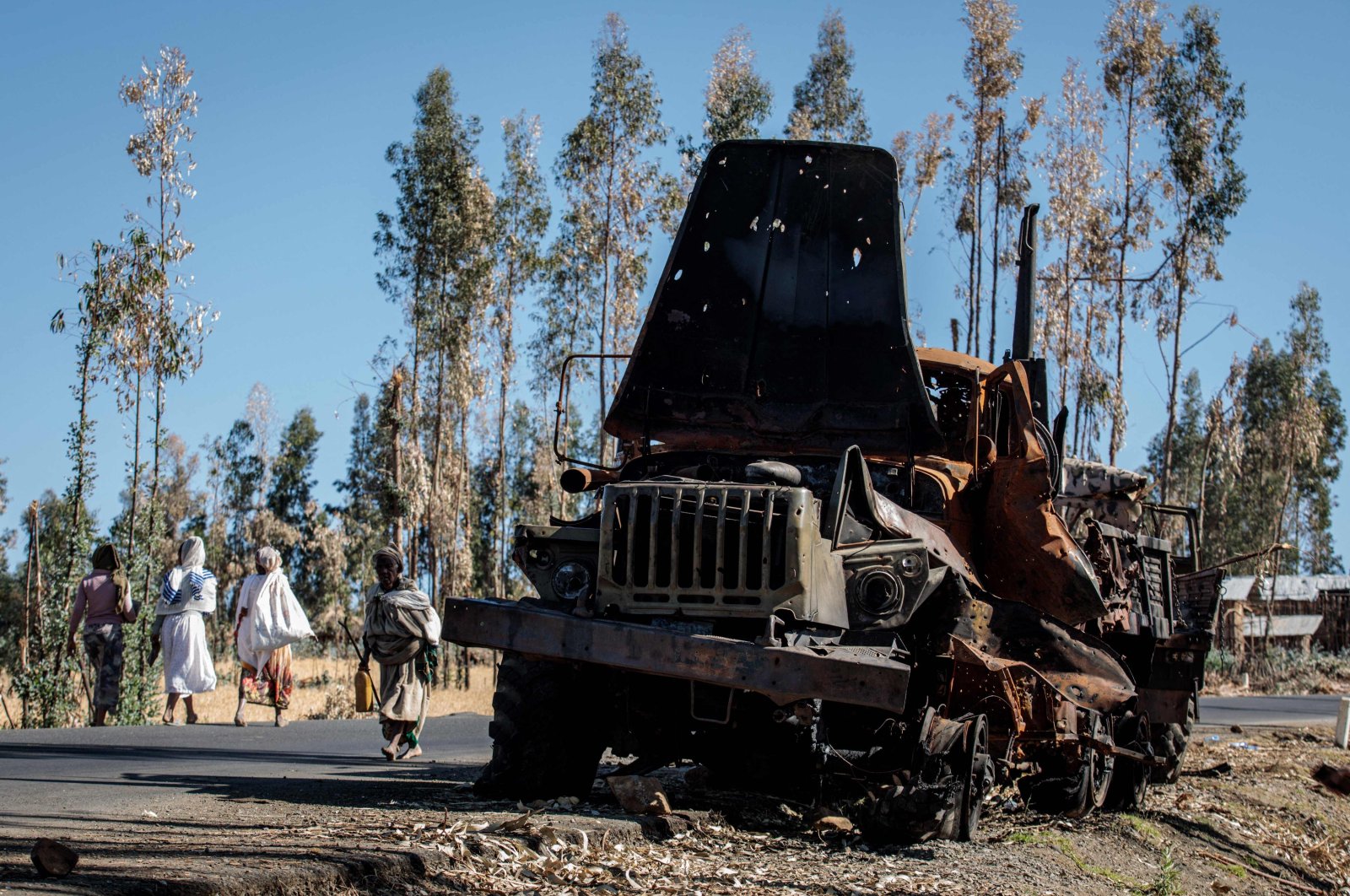 Women walk past a disused military truck near Sali, Ethiopia, Dec. 6, 2021.  (AFP Photo)