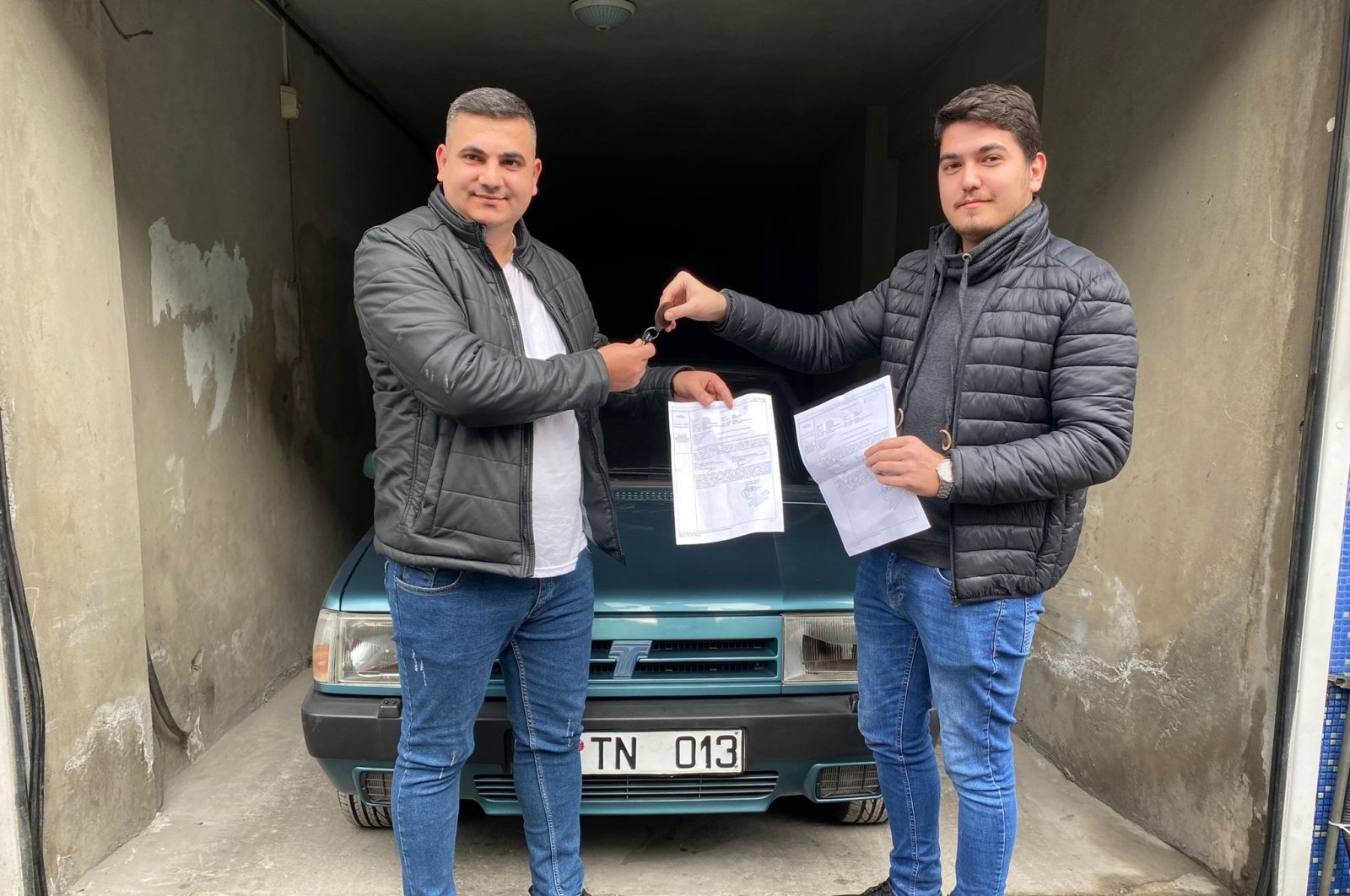 Sercan Deniz and Muhammet Maden exchanging documents and keys in the sale of the cult classic, Istanbul, Turkey, Dec. 14, 2021 (IHA Photo)