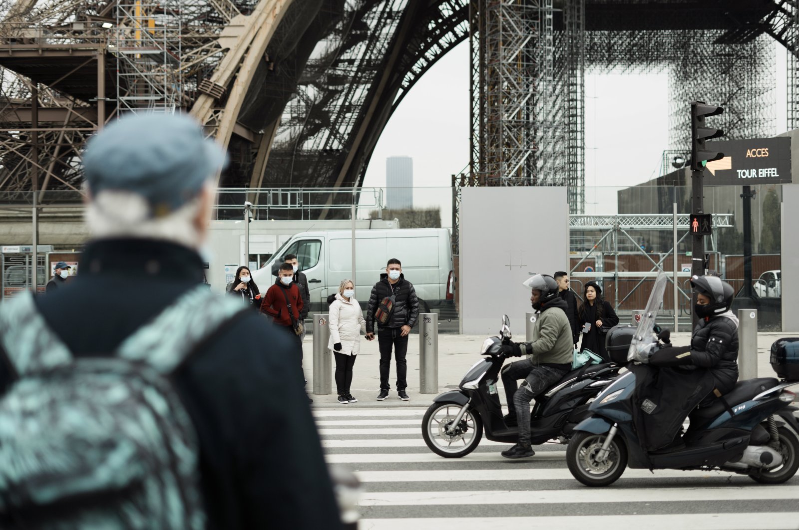 Pedestrians wear masks to prevent the spread of the COVID-19 as they wait at a crosswalk, near the Eiffel Tower, in Paris, France, Dec. 14, 2021. (AP Photo)
