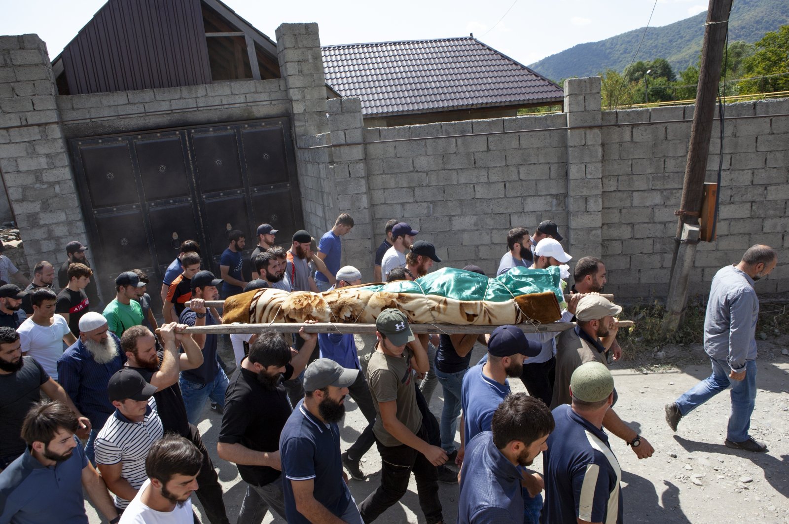 People carry the body of Zelimkhan Khangoshvili, a Georgian Muslim, during his funeral in Duisi village, the Pankisi Gorge valley, Georgia, Aug. 29, 2019. (AP Photo)