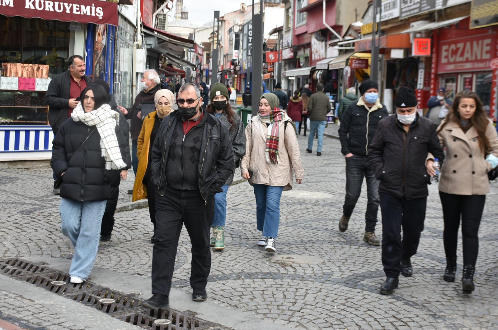A mix of people wearing and not wearing protective masks against COVID-19 walk on a street in Edirne, northwestern Turkey, Dec. 15, 2021. (DHA PHOTO) 