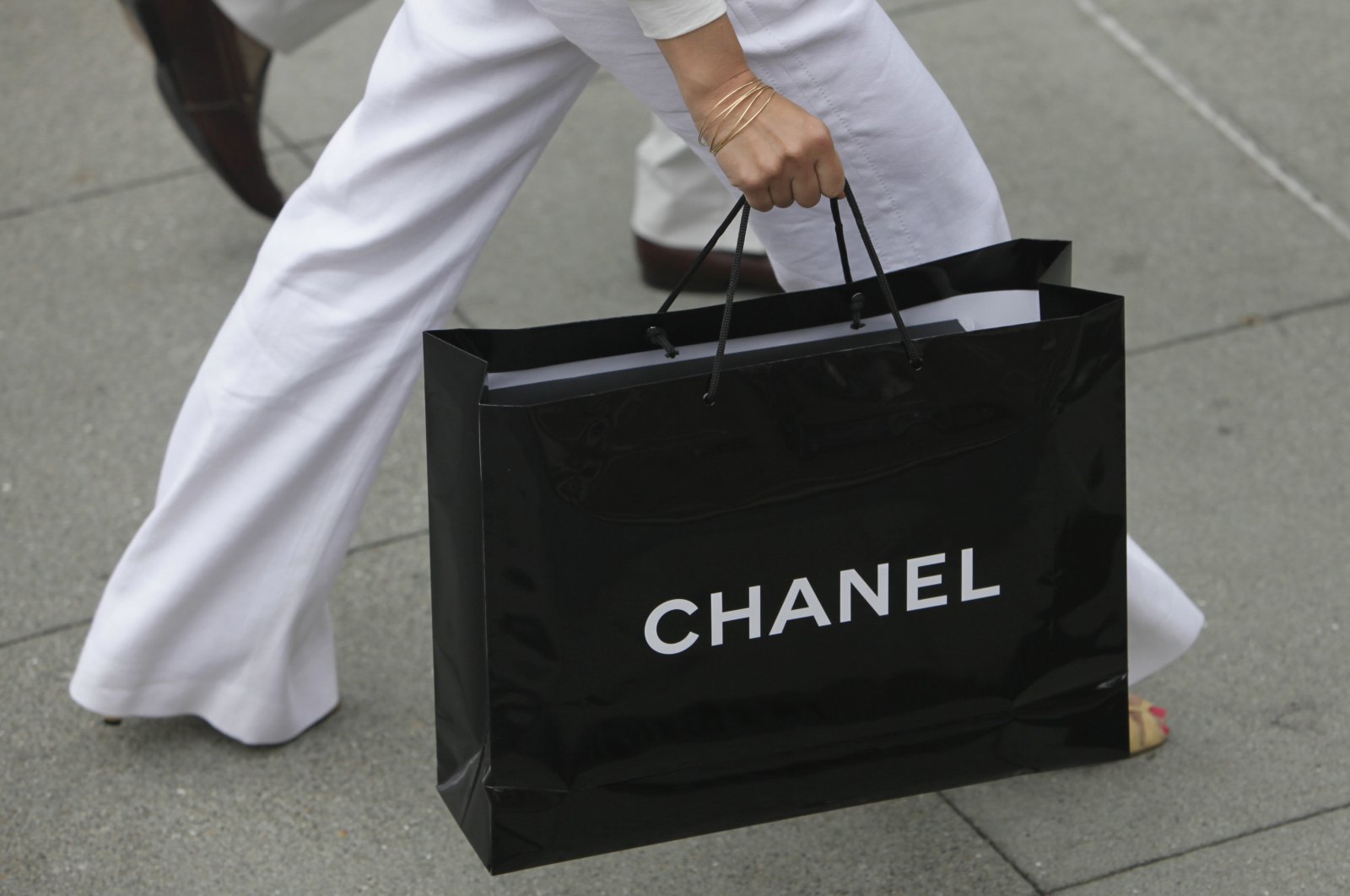 A woman carries a bag from Chanel while walking through Union Square in San Francisco, July 28, 2009. (AP Photo)