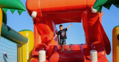 Young Boy Jumping on Bouncy Castle. (Shutterstock Photo) 