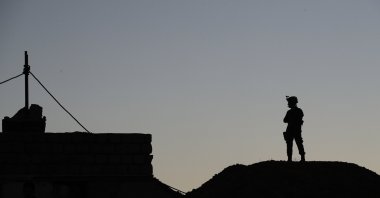 A Kurdish Peshmerga soldier is silhouetted near a military outpost on the outskirts of the city of Mosul, Iraq, Jan. 2, 2017. (AP File Photo)