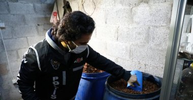 A police officer checks materials used in bootleg liquor production seized in an operation in Adana, southern Turkey, Dec. 16, 2021. (PHOTO BY ZİYA RAMOĞLU)