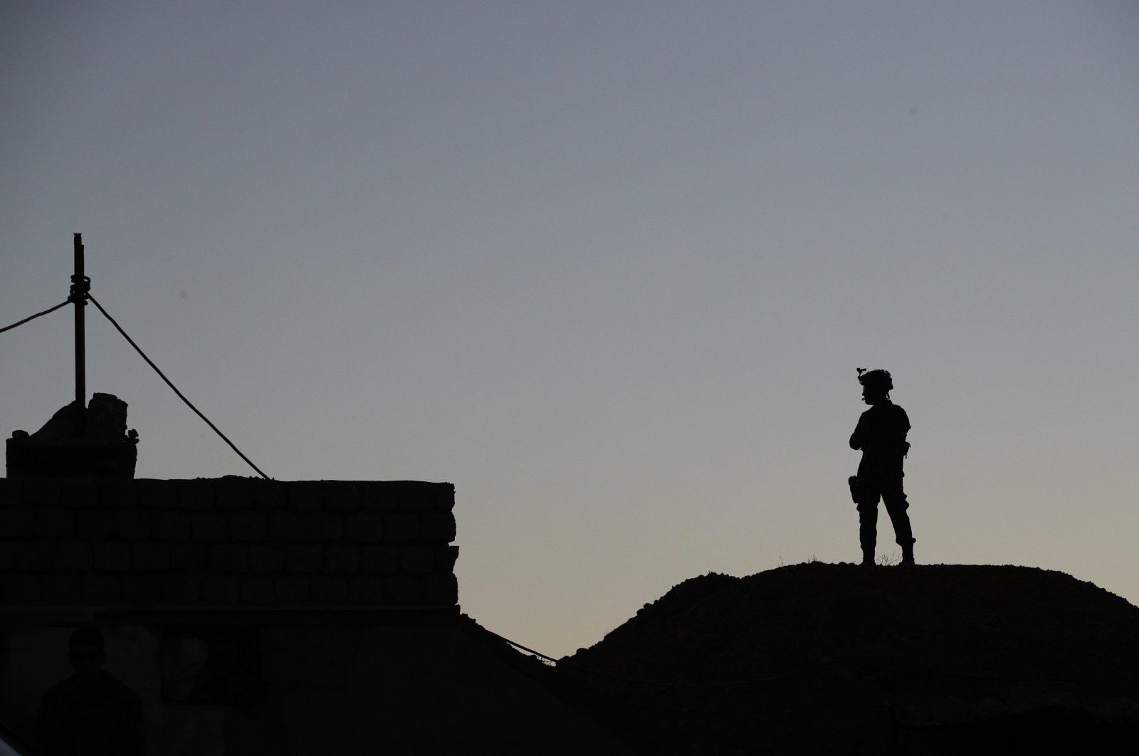 A Kurdish Peshmerga soldier is silhouetted near a military outpost on the outskirts of the city of Mosul, Iraq, Jan. 2, 2017. (AP File Photo)