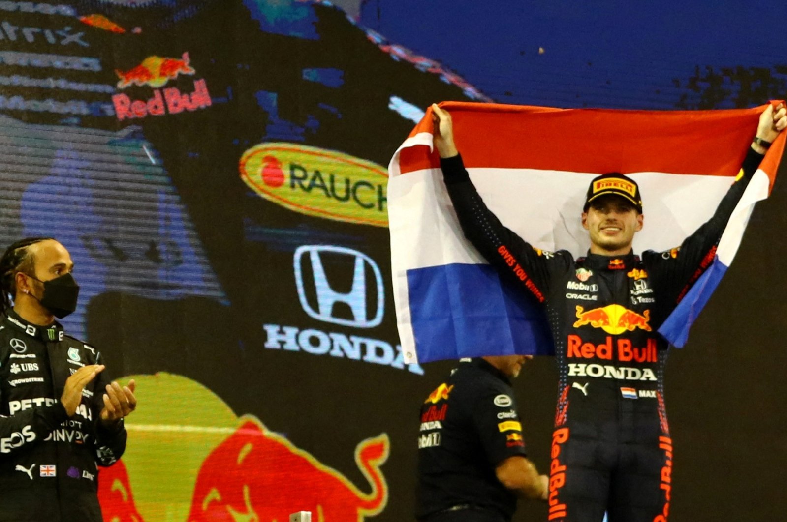 Red Bull&#039;s Max Verstappen (R) celebrates winning the Abu Dhabi GP and F1 world title as Mercedes&#039; Lewis Hamilton looks on, Abu Dhabi, UAE, Dec. 12, 2021.