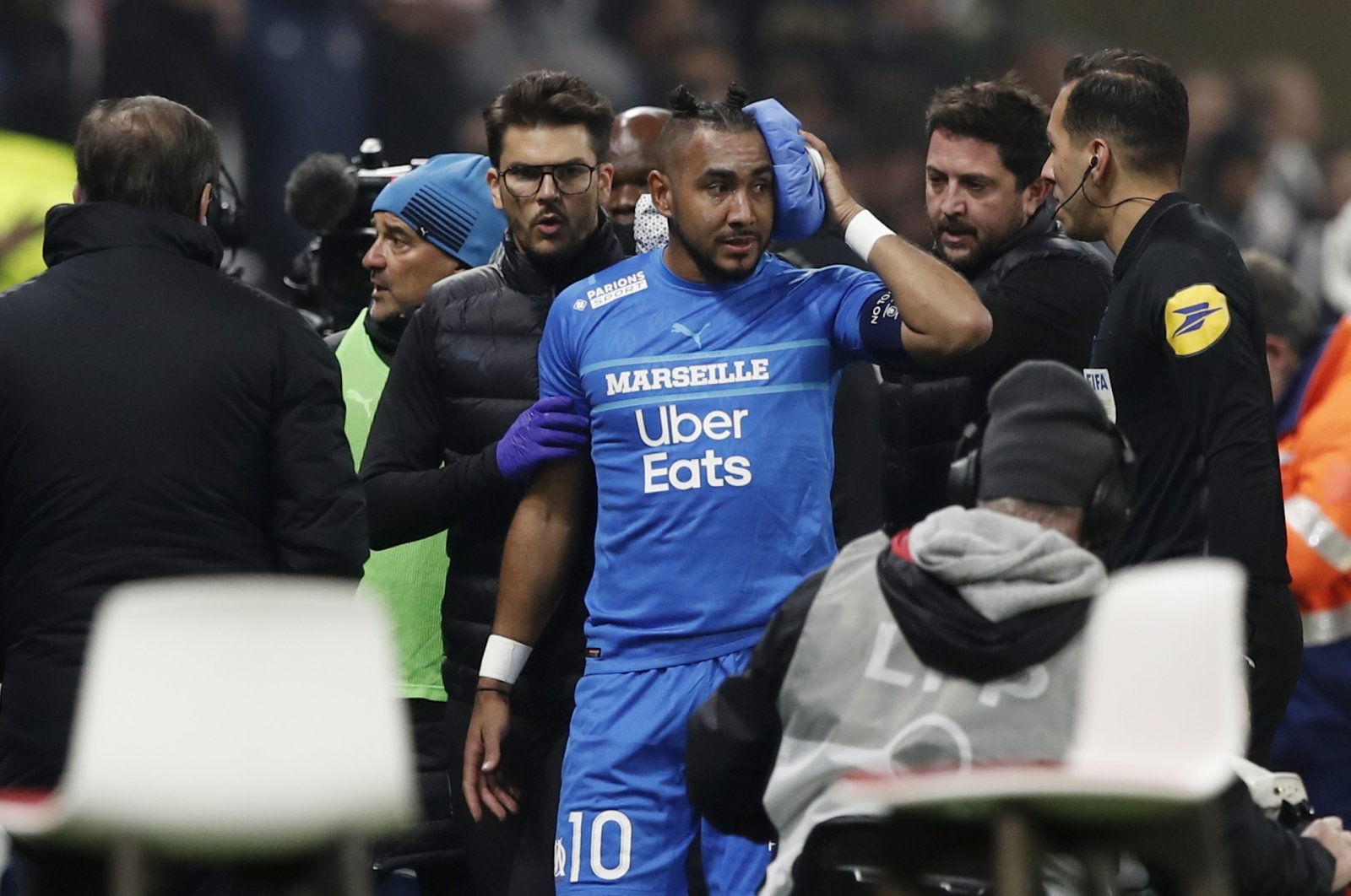 Marseille&#039;s Dimitri Payet (C) walks off the pitch injured after being hit by a water bottle thrown by a fan, Lyon, France, Nov. 21, 2021. (Reuters Photo)