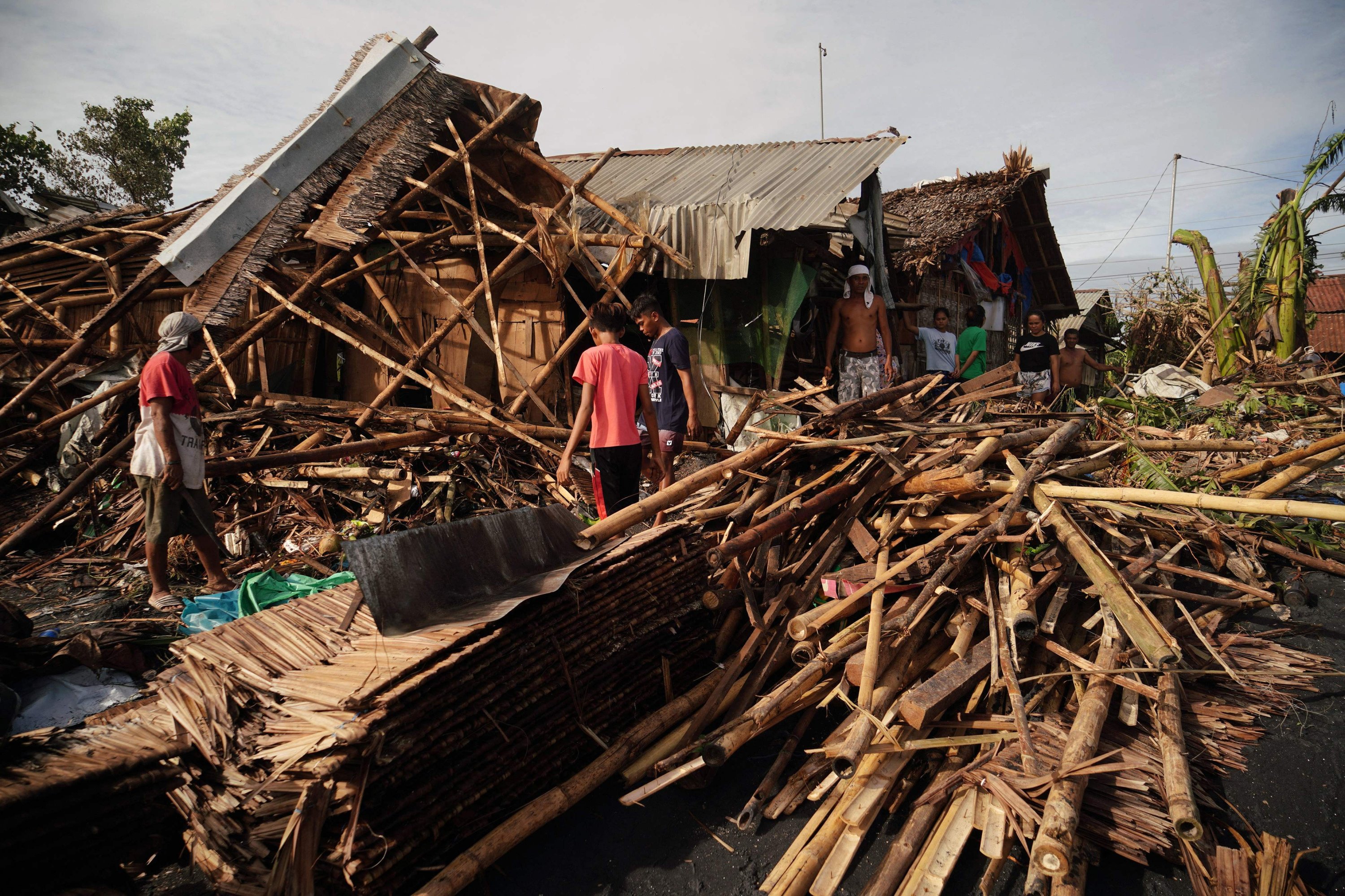 Warga menyelamatkan barang-barang dari rumah mereka yang hancur di kota pesisir Dulag di provinsi Leyte sehari setelah Topan Rai melanda, Filipina, 17 Desember 2021. (AFP Photo)