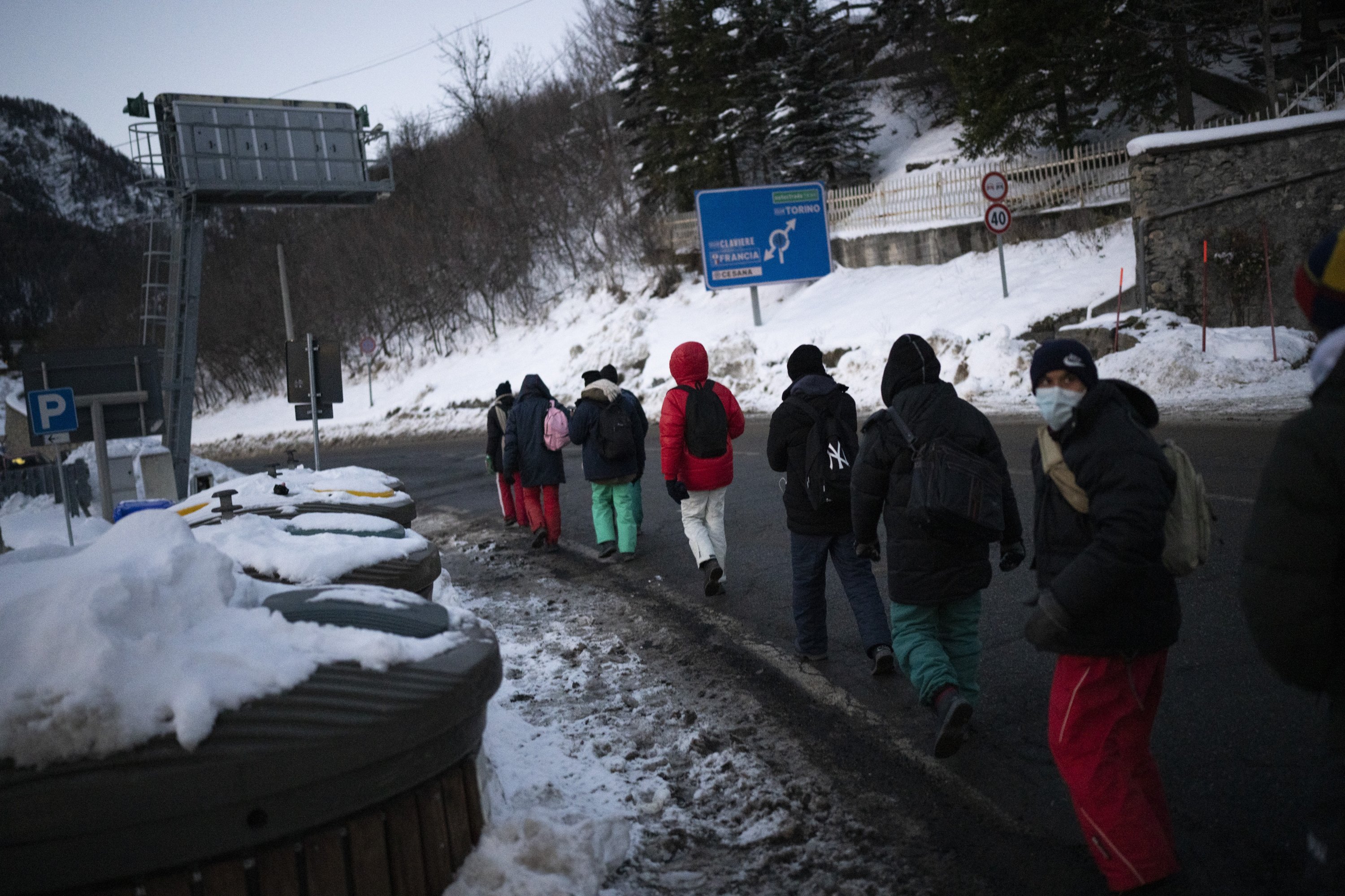 Migrants headed to France from Italy walk along a mountain road leading to the French-Italian border, Dec. 11, 2021. (AP Photo)