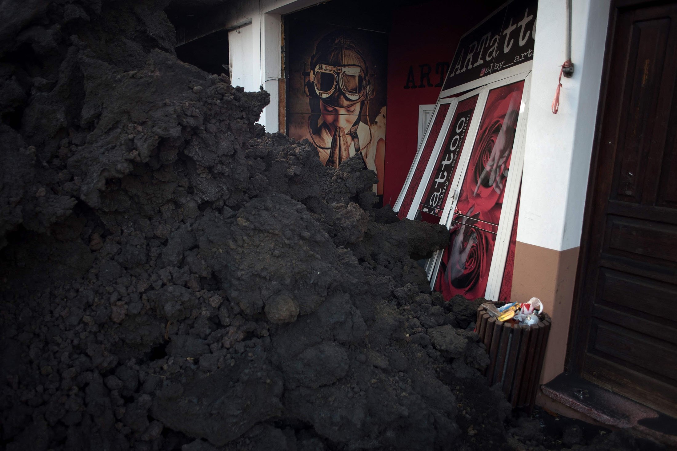 Sebuah rumah ditutupi dengan tumpukan lava, menyusul letusan gunung berapi Cumbre Vieja, di La Laguna, di Pulau Canary La Palma, Spanyol, 16 Desember 2021. (AFP Photo)