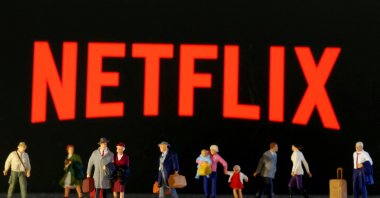 Small toy figures are seen in front of diplayed Netflix logo in this illustration, March 19, 2020. (Reuters Photo)