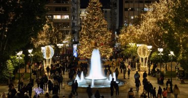 People walk at the Christmas decorated Syntagma square in Athens, Greece, Dec. 15, 2021. (AP Photo)