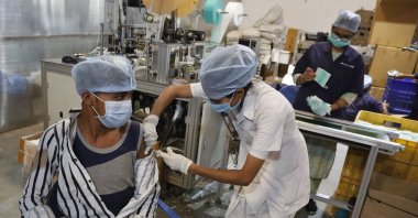 An Indian health worker administers the Covishield vaccine for COVID-19 to a worker at the factory of a face mask manufacturer on the outskirts of Ahmedabad, India, Friday, Dec. 17, 2021. (AP Photo)