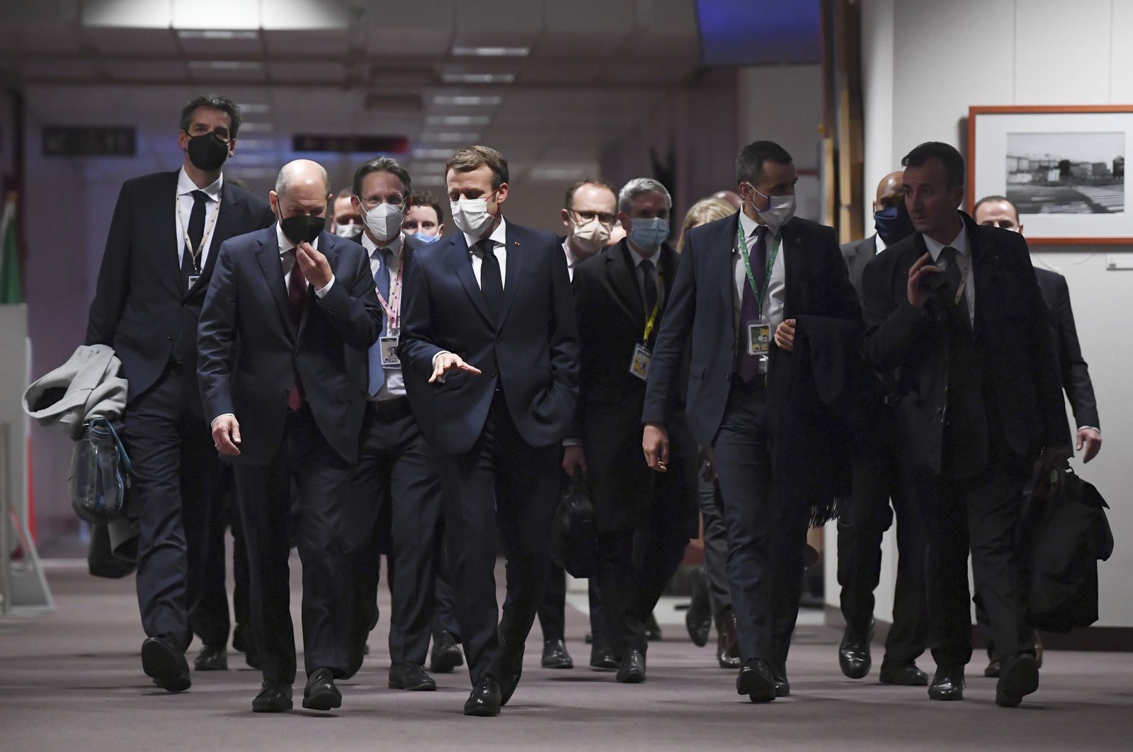 German Chancellor Olaf Scholz (2nd L) and French President Emmanuel Macron (C) walk in the hallway prior to a final media conference at an EU Summit in Brussels, Belgium, Dec. 17, 2021. (AP Photo)
