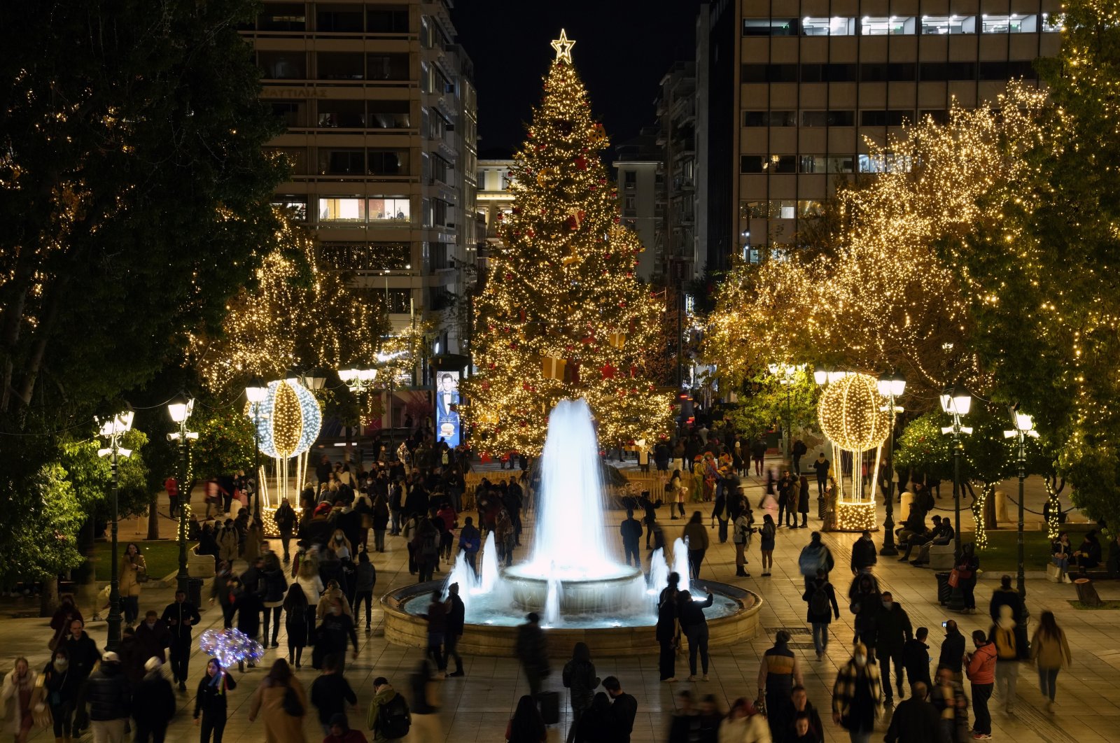 People walk at the Christmas decorated Syntagma square in Athens, Greece, Dec. 15, 2021. (AP Photo)