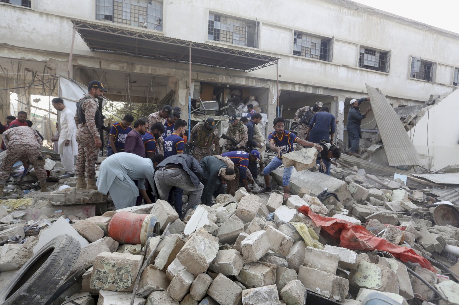 Pakistani security personnel and rescuers inspect the scene of a gas explosion in Karachi, Pakistan, Dec. 18, 2021. (AP Photo)