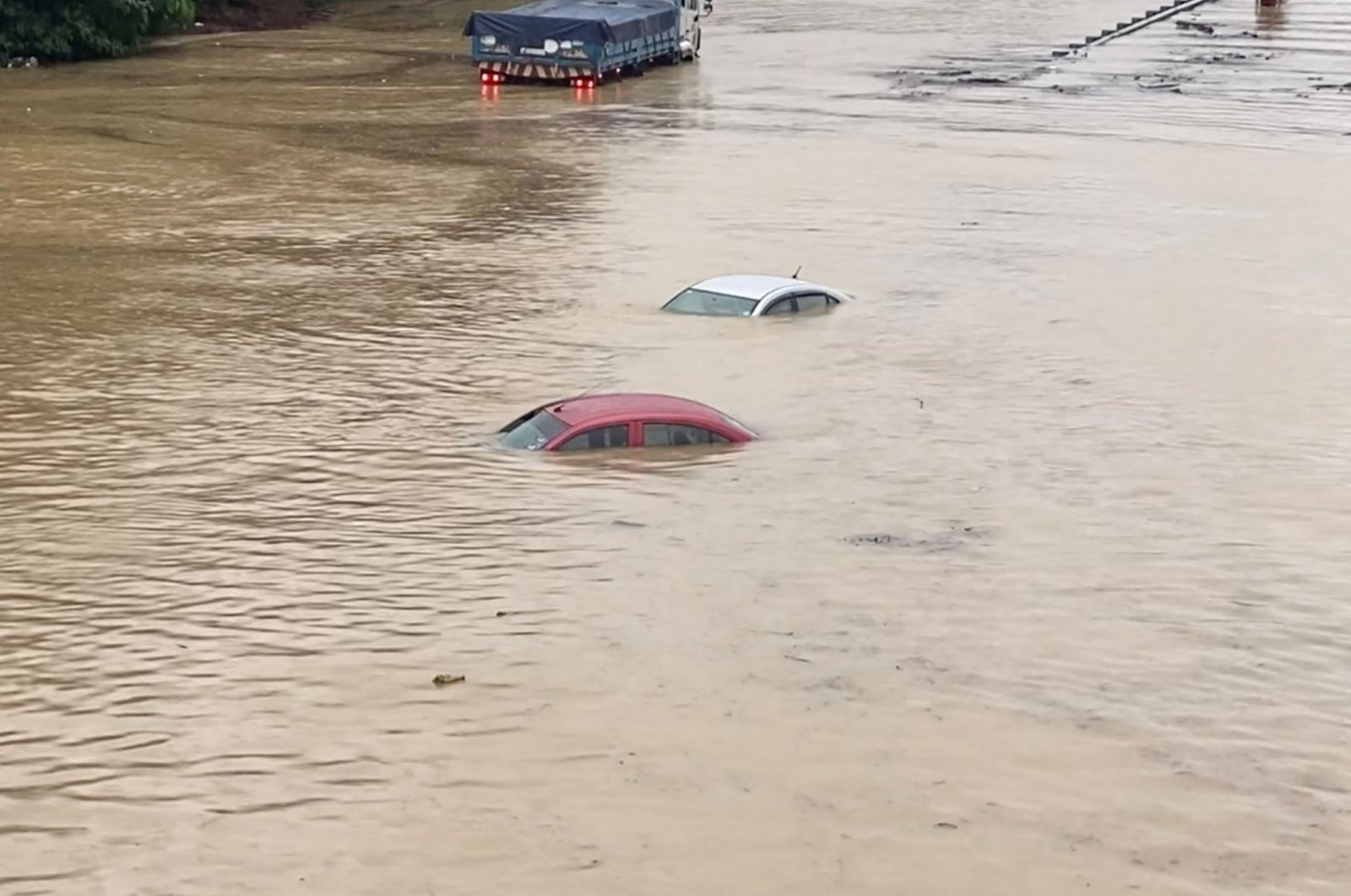 Partially submerged cars are seen on a flooded road in Shah Alam, Malaysia, Dec. 18, 2021. (Reuters)