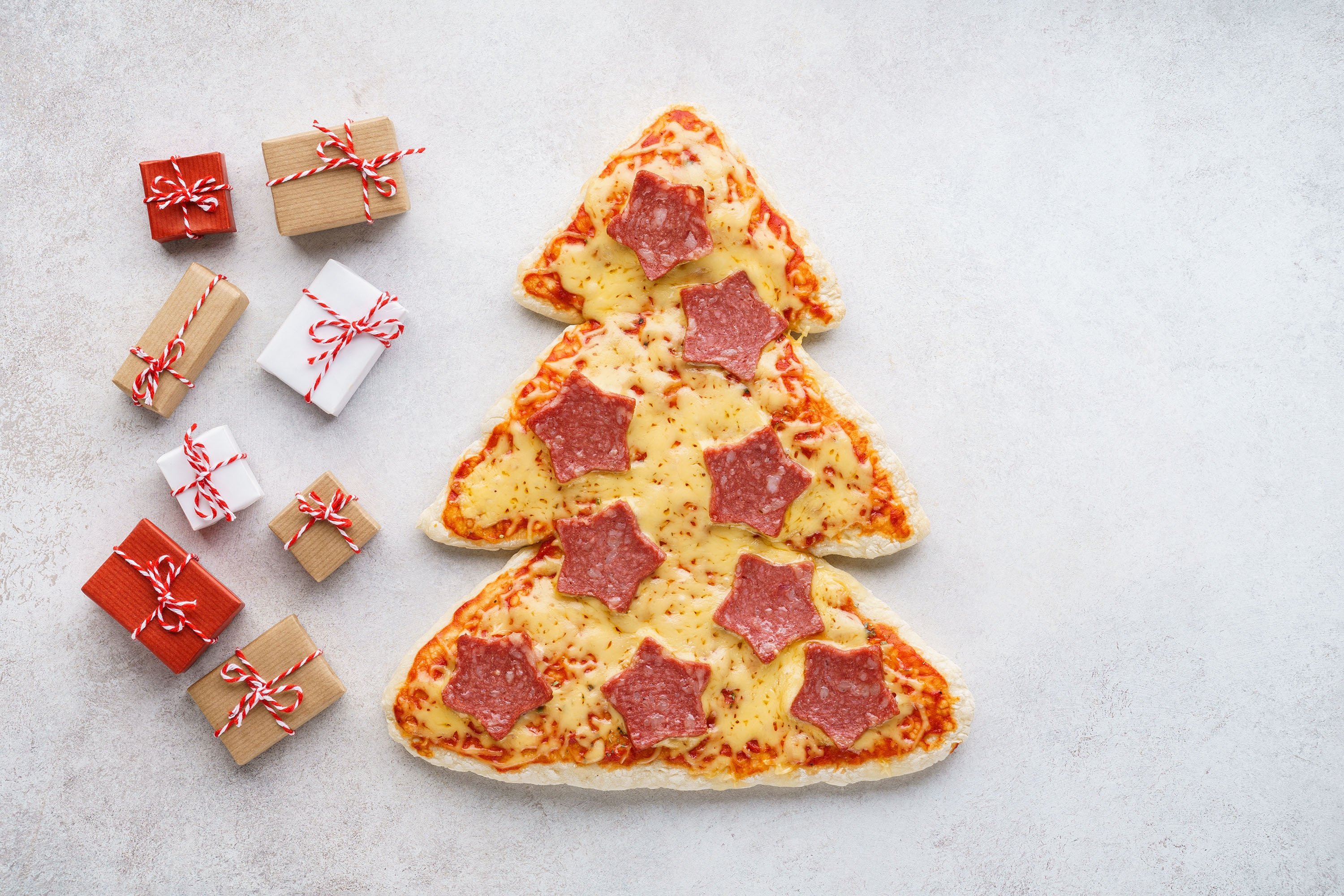 Pepperoni pizza shaped as a Christmas tree and gift boxes. (Shutterstock Photo)