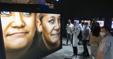 People take in the "Human   Machine" NFTS art exhibition, during the general public opening day of the Art Basel Miami Beach fair at the Miami Beach Convention Center in Miami, Florida, U.S., Dec. 2, 2021. (EPA Photo)
